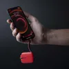 A hand holding a smartphone that is connected to a red power bank. Náhled obrázku produktu