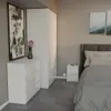 A bedroom scene with a bed, nightstand, dresser, and artwork. Voir les images du produit