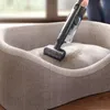 A person is vacuuming a pet bed. Voir les images du produit