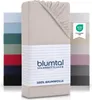 A stack of folded fitted sheets in various colors, with one sheet prominently displayed in the foreground. Produktbild-Vorschau