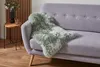 Schaffell Teppcih ausgelegt auf einer Couch.  Produktbild-Vorschau
