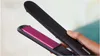 A hand holding a black Philips hair straightener with pink plates. Voir les images du produit