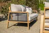 A modern outdoor lounge set with a sofa and a chair, placed on a gravel patio with a hedge in the background. Produktbild-Vorschau