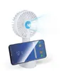 A white portable fan with misting function is shown, mounted on a stand holding a smartphone. Produktbild-Vorschau