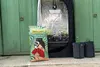 A bag of Floragard Professional Growmix Organic is placed in front of a grow tent, with two fabric pots to the right. Produktbild-Vorschau