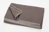 A folded brown blanket with a decorative stitched edge, presented on a white background. Produktbild-Vorschau