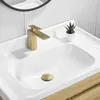 A close-up view of a bathroom sink with a gold faucet and drain. Produktbild-Vorschau
