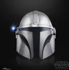 A close-up studio shot of a silver Mandalorian helmet with a blue light emitting from the side. Voir les images du produit