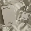 A perfume bottle and its box are placed on a white, wrinkled fabric. Anteprima dell’immagine prodotto