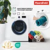 A washing machine with several rolled-up bath mats in various colors next to it, and a hand placing a teal mat into the washing machine. Produktbild-Vorschau