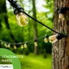 A string of outdoor lights is draped across a tree in a garden setting. Produktbild-Vorschau