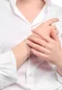 A close-up shot of a person wearing a white shirt and a diamond bracelet. Produktbild-Vorschau