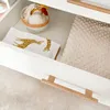 An open drawer of a dresser or changing table, showing baby items inside. Podgląd zdjęcia produktu