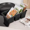 A black kitchen organizer filled with spice packets sits on a countertop next to a stovetop. Náhľad obrázku produktu