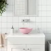 A close-up view of a pink ceramic sink on a white vanity in a tiled bathroom. Podgląd zdjęcia produktu