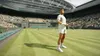A tennis player stands on a grass court in a stadium with spectators in the background. Produktbild-Vorschau