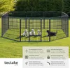A black metal dog playpen with puppies inside, set up on a grassy lawn. Produktbild-Vorschau