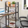 A desk with a bookshelf unit next to it, featuring a laptop and various books. Náhled obrázku produktu