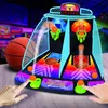 A close-up shot of a dual-lane electronic arcade basketball game with two players' hands interacting with the game. Produktbild-Vorschau