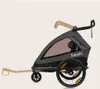 A side view of a gray and black child trailer for a bicycle, shown on a plain background. Produktbild-Vorschau