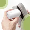 Hands are holding a white Belkin charger and placing it into a grey pouch. Produktbild-Vorschau