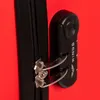 A close-up of a red suitcase zipper and combination lock. Produktbild-Vorschau