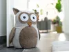 A stuffed owl doorstop sits on a floor next to a doorway. Anteprima dell’immagine prodotto