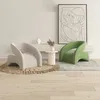 Two modern armchairs, one beige and one green, are placed in a living room setting with a piece of abstract art on the wall. Anteprima dell’immagine prodotto