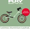 A light green Puky balance bike is shown against a solid light green background. Text overlays highlight features. Produktbild-Vorschau