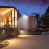 A modern house at dusk with a solar-powered street lamp illuminating the driveway. Produktbild-Vorschau
