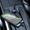 A car's center console with a USB car charger plugged in and two smartphones charging. Náhľad obrázku produktu