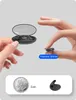Hands are holding and displaying a small black wireless earbud and a charging case, with a coin for size comparison. Produktbild-Vorschau