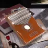 A kalimba instrument is placed on top of a book and sheet music. Produktbild-Vorschau