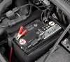A close-up view of a car battery with jumper cables attached. Náhled obrázku produktu