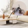 A living room scene with a coffee table, sofa, and a vase of flowers. A close-up inset shows hands cutting a self-adhesive cat scratching mat. Produktbild-Vorschau