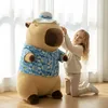 A young girl is interacting with a large capybara plush toy. Produktbild-Vorschau