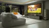 A modern living room set up as a home theater with a large projection screen displaying a family photo. Produktbild-Vorschau