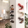 A collection of shoes displayed on wall-mounted shelves in a room with a lamp and plants. Produktbild-Vorschau