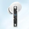 A close-up view of a white wireless earbud, showing its internal circuitry and a digital display indicating '5.2 Bluetooth'. The background is a soft gradient of light blue and white. Produktbild-Vorschau