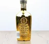 A gold-colored bottle of gin sits on a wooden surface. Anteprima dell’immagine prodotto