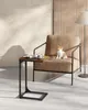 A small side table with a book and cup of coffee next to a chair with a cat on it. Náhled obrázku produktu