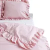 A pink bedding set with ruffles on a white surface. Náhled obrázku produktu