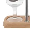 A close-up view of the base of a coffee machine with a wooden stand and glass components. Náhled obrázku produktu