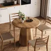 A round wooden dining table with chairs in a kitchen setting. Produktbild-Vorschau