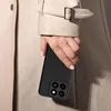 A person's hand holding a black smartphone case, with a trench coat in the background. Anteprima dell’immagine prodotto