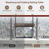 A folding railing table is shown attached to a railing with a city skyline in the background, split between a rainy and sunny depiction. Podgląd zdjęcia produktu