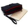 A black travel bag with red lining is shown next to a gold smartphone. Produktbild-Vorschau