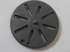 A round, dark gray metal grate with slots is shown on a light gray surface. Anteprima dell’immagine prodotto