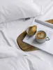 A close-up shot of a white duvet with a cup of coffee and a cookie on a magazine. Produktbild-Vorschau