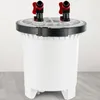 A white cylindrical water filter with two red and black spigots on top, set against a light gray and white background. Podgląd zdjęcia produktu